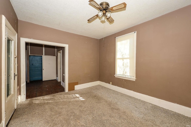 carpeted empty room featuring ceiling fan and a textured ceiling