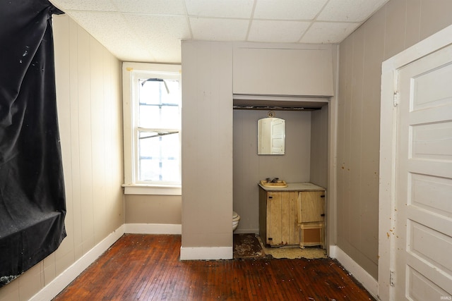 details featuring wood-type flooring, a paneled ceiling, and wooden walls