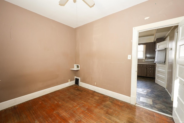 laundry area with ceiling fan and dark wood-type flooring