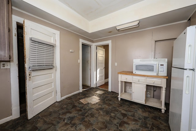 kitchen with white appliances, white cabinetry, and butcher block counters