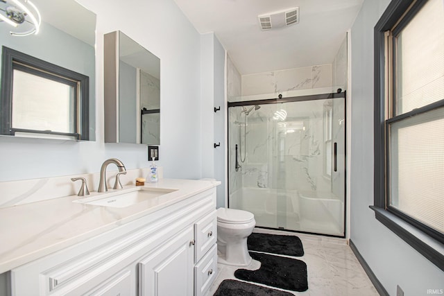 bathroom featuring a shower with door, vanity, plenty of natural light, and toilet