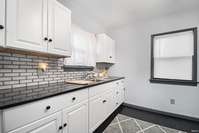 kitchen featuring tasteful backsplash, sink, and white cabinets