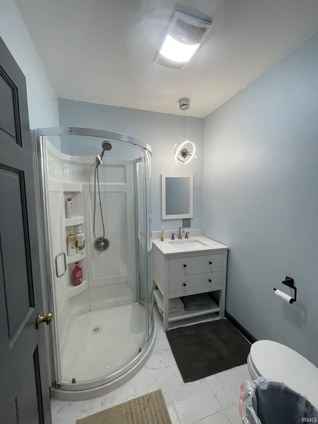 bathroom with vanity, a shower with shower door, and toilet