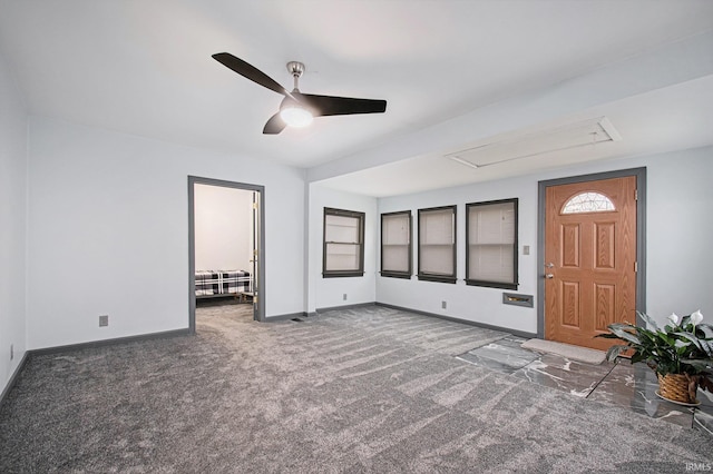 unfurnished living room featuring ceiling fan and dark colored carpet