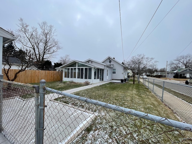 view of front of property featuring a sunroom and a front lawn