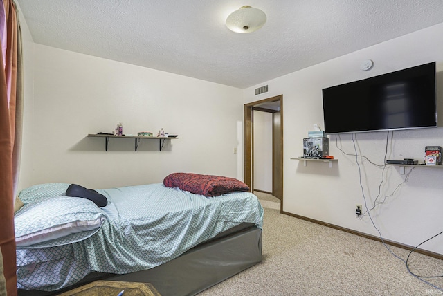 bedroom featuring carpet flooring and a textured ceiling