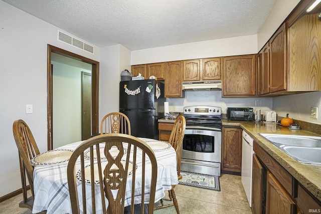 kitchen featuring light tile patterned floors, a textured ceiling, black fridge, and electric stove