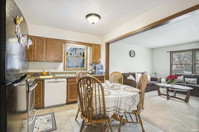 carpeted dining area featuring a textured ceiling