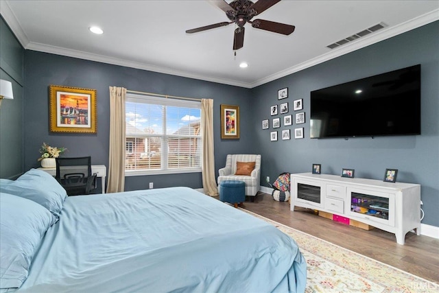 bedroom with ceiling fan, hardwood / wood-style floors, and crown molding