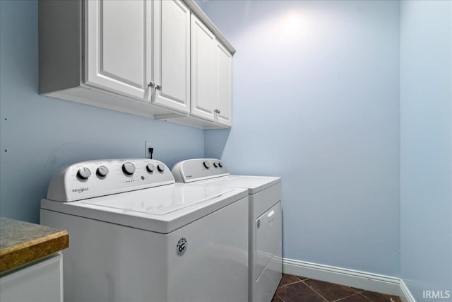 washroom featuring dark tile patterned floors, cabinets, and separate washer and dryer