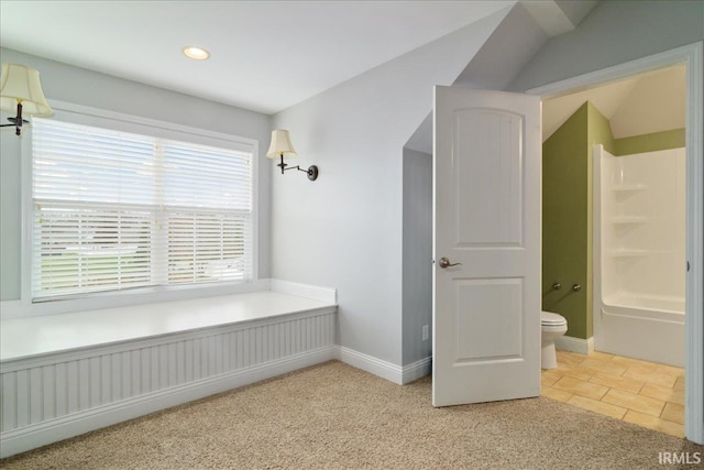 bathroom with tile patterned flooring, vaulted ceiling, shower / bathtub combination, and toilet