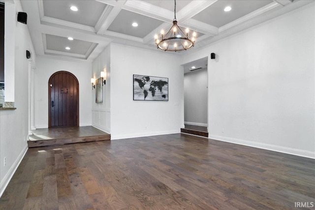 interior space featuring beam ceiling, coffered ceiling, dark hardwood / wood-style flooring, a chandelier, and ornamental molding