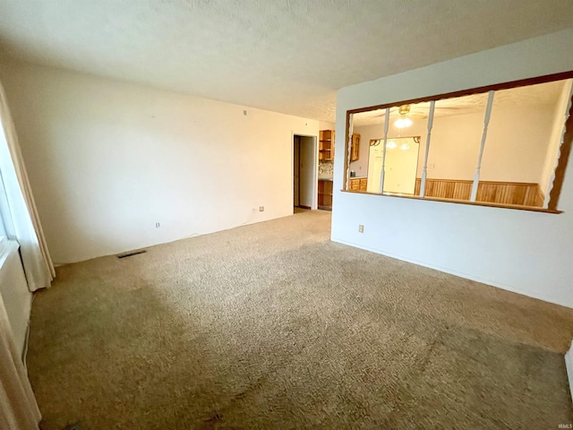 carpeted empty room featuring a textured ceiling