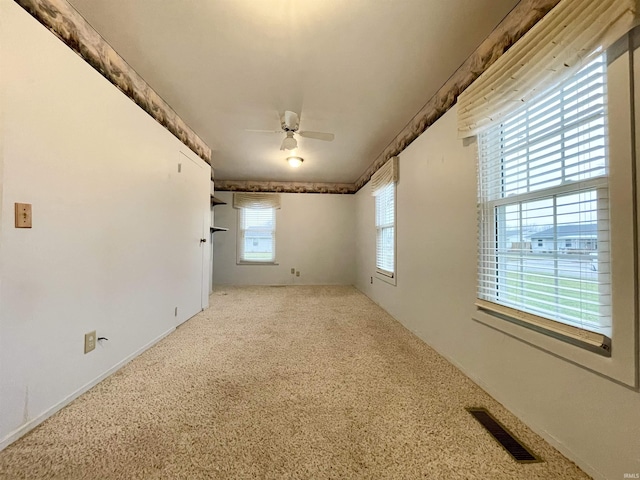 carpeted spare room featuring ceiling fan