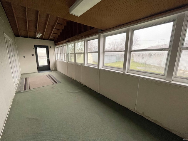 unfurnished sunroom featuring vaulted ceiling