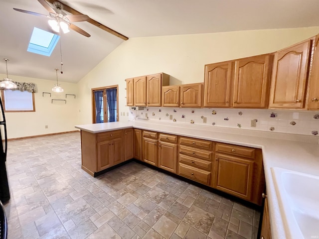 kitchen featuring kitchen peninsula, backsplash, a skylight, sink, and hanging light fixtures