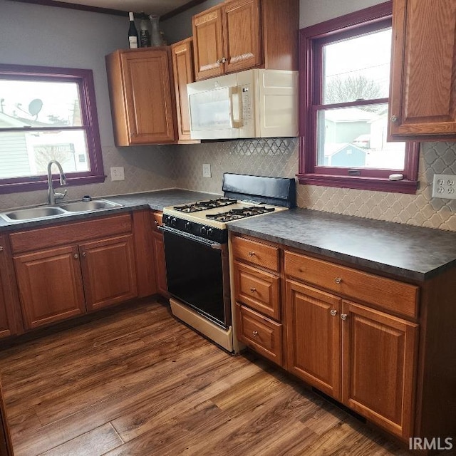 kitchen featuring backsplash, dark hardwood / wood-style flooring, white appliances, and sink