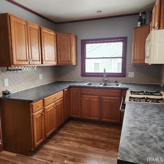 kitchen featuring decorative backsplash, ornamental molding, white appliances, sink, and dark hardwood / wood-style floors