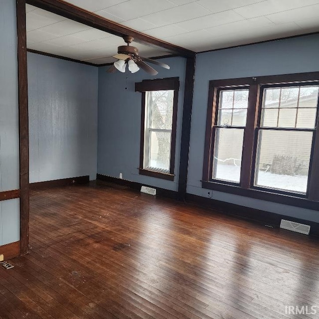 spare room featuring beamed ceiling, dark hardwood / wood-style floors, and ceiling fan