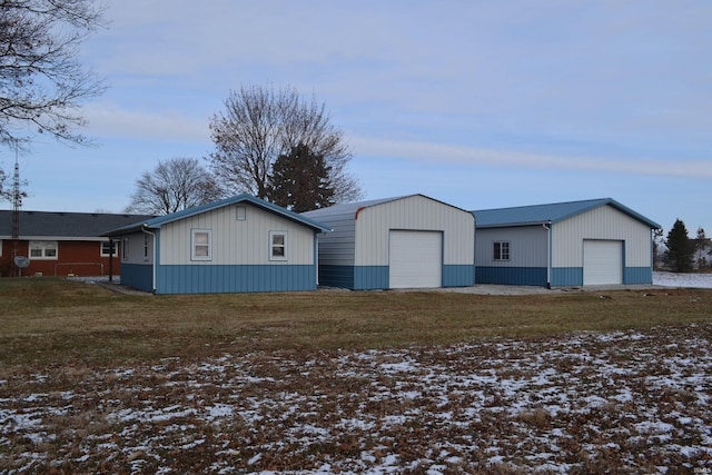 exterior space featuring a lawn, a garage, and an outdoor structure