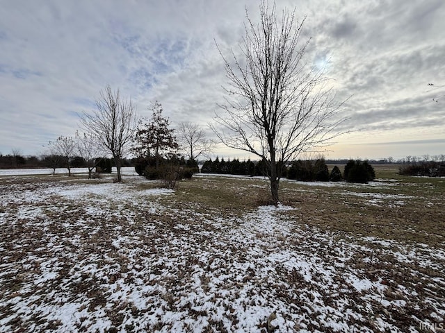 yard covered in snow with a rural view