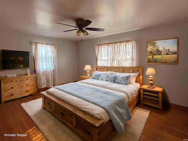 bedroom with ceiling fan and dark hardwood / wood-style floors