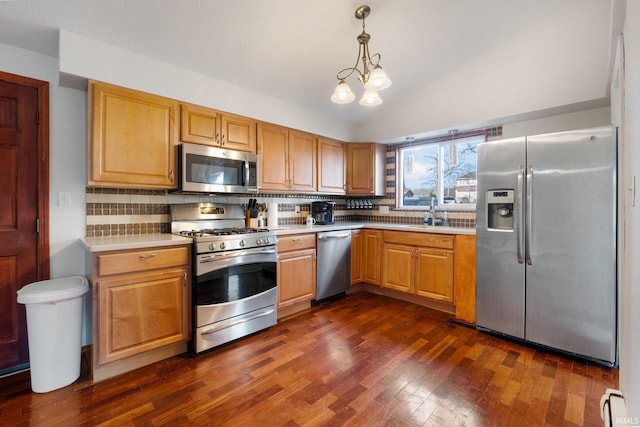 kitchen featuring appliances with stainless steel finishes, tasteful backsplash, dark hardwood / wood-style floors, hanging light fixtures, and lofted ceiling