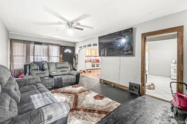 living room with ceiling fan and dark wood-type flooring