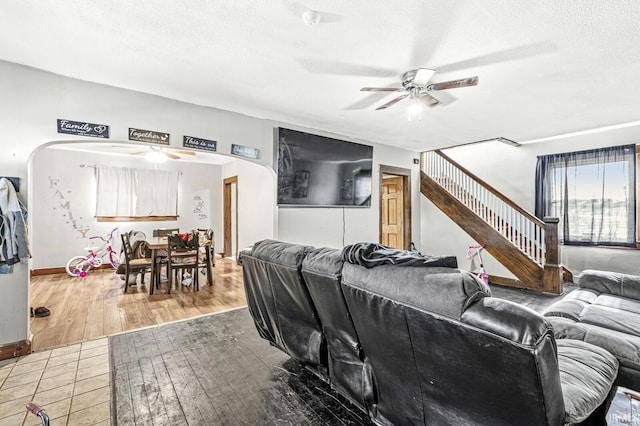 living room featuring ceiling fan, wood-type flooring, and a textured ceiling