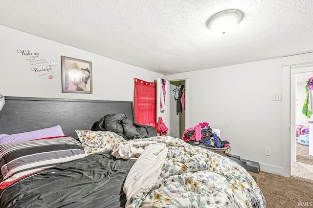 bedroom with carpet floors and a textured ceiling