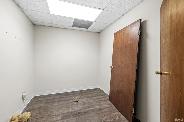 empty room featuring a paneled ceiling and dark hardwood / wood-style flooring