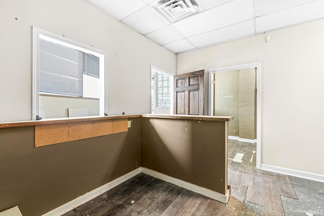 unfurnished room with a paneled ceiling and hardwood / wood-style flooring