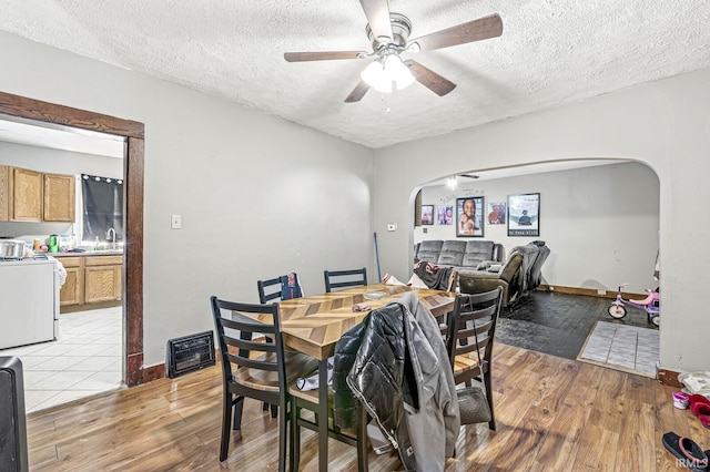 dining room featuring ceiling fan, light hardwood / wood-style floors, sink, and a textured ceiling