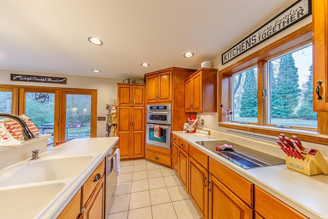 kitchen with light tile patterned floors, sink, and appliances with stainless steel finishes