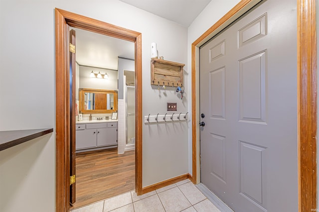 corridor with light hardwood / wood-style floors and sink