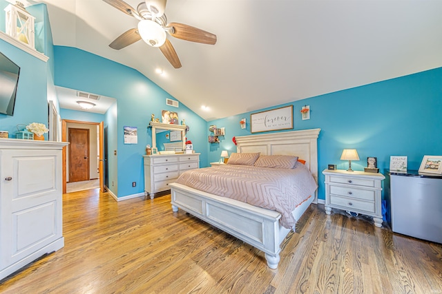 bedroom with ceiling fan, hardwood / wood-style floors, and lofted ceiling