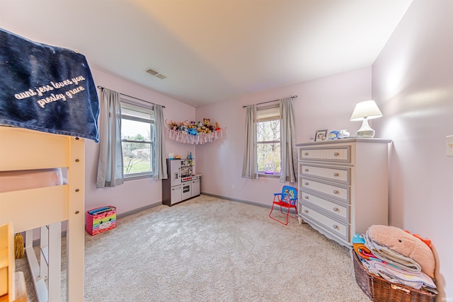 bedroom featuring light colored carpet and multiple windows