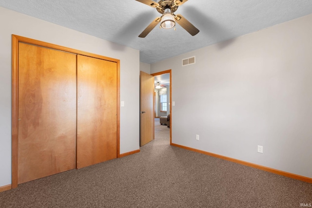 unfurnished bedroom with ceiling fan, a textured ceiling, and a closet