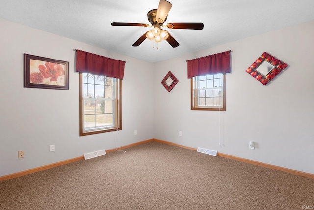 unfurnished room with ceiling fan, carpet floors, a textured ceiling, and a wealth of natural light