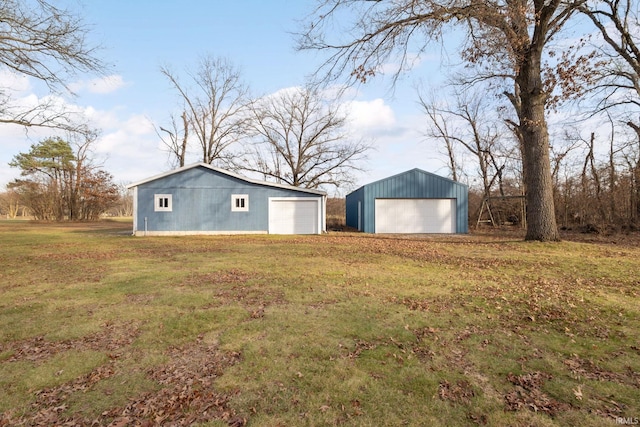 exterior space featuring a lawn, an outbuilding, and a garage