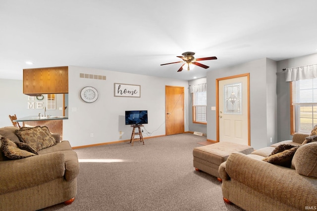 living room featuring carpet floors, ceiling fan, and sink