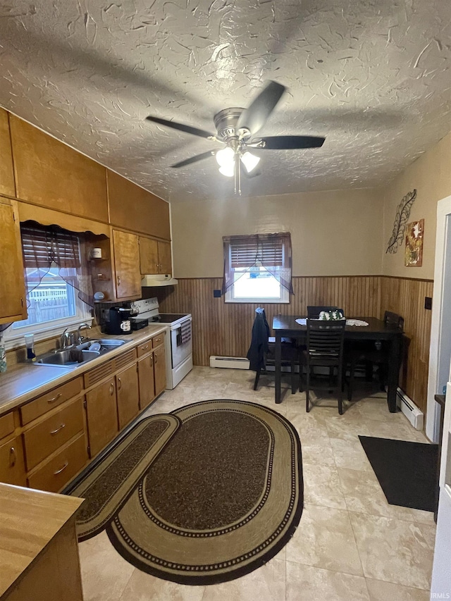 kitchen with a textured ceiling, electric range, baseboard heating, and sink