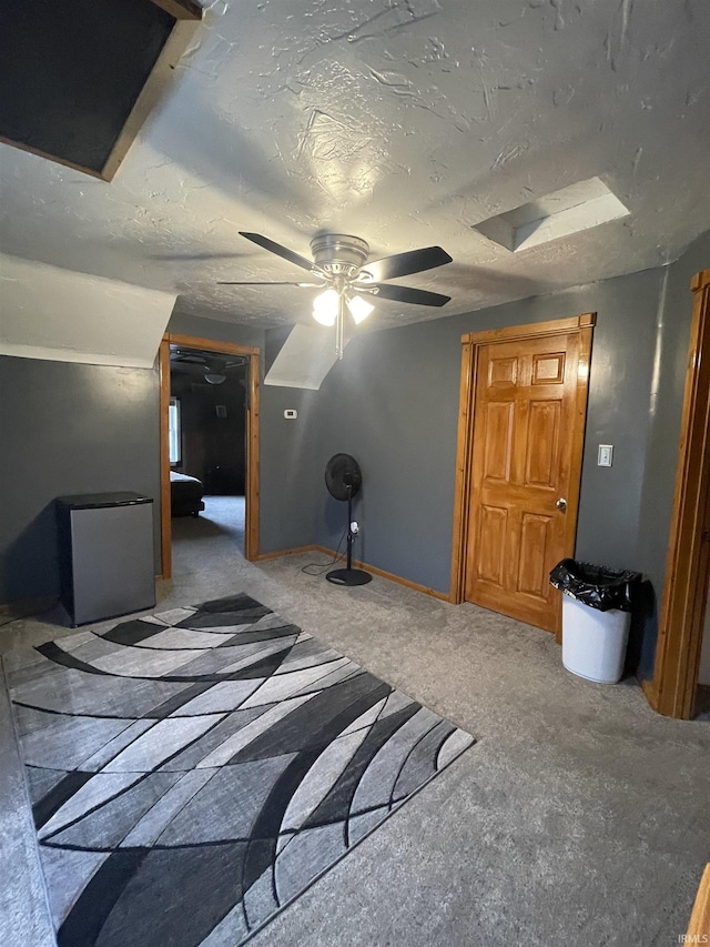 unfurnished bedroom featuring ceiling fan, carpet floors, a textured ceiling, and stainless steel refrigerator