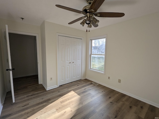 unfurnished bedroom with hardwood / wood-style floors, ceiling fan, and a closet