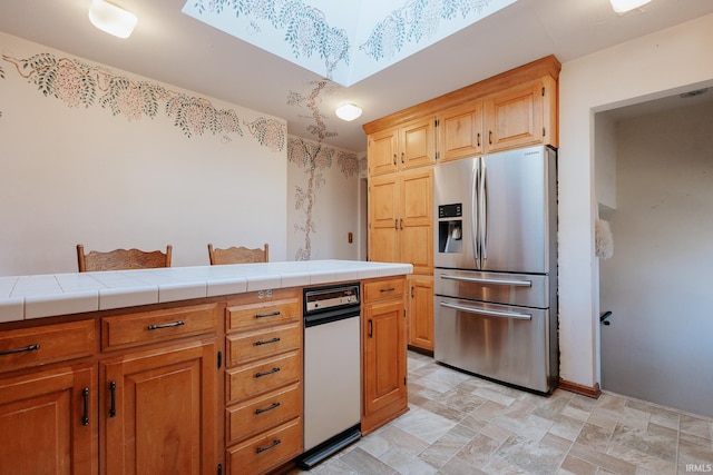 kitchen with tile counters and stainless steel refrigerator with ice dispenser