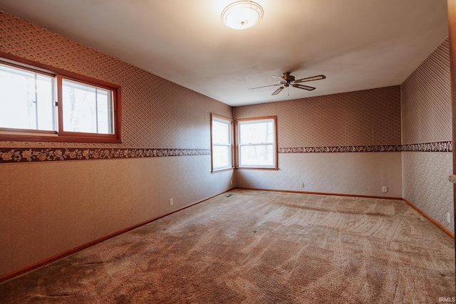 carpeted empty room with plenty of natural light and ceiling fan