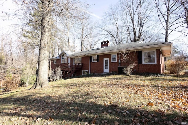 view of front of house with a front yard, a deck, and central AC unit