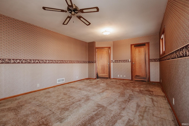 carpeted spare room featuring ceiling fan