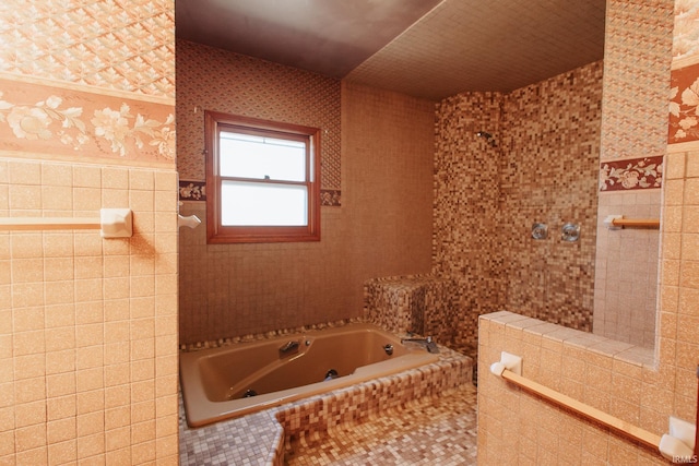 bathroom featuring a bath and tile walls