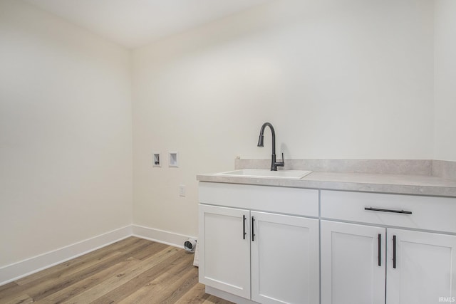 laundry room with cabinets, sink, light hardwood / wood-style floors, and washer hookup